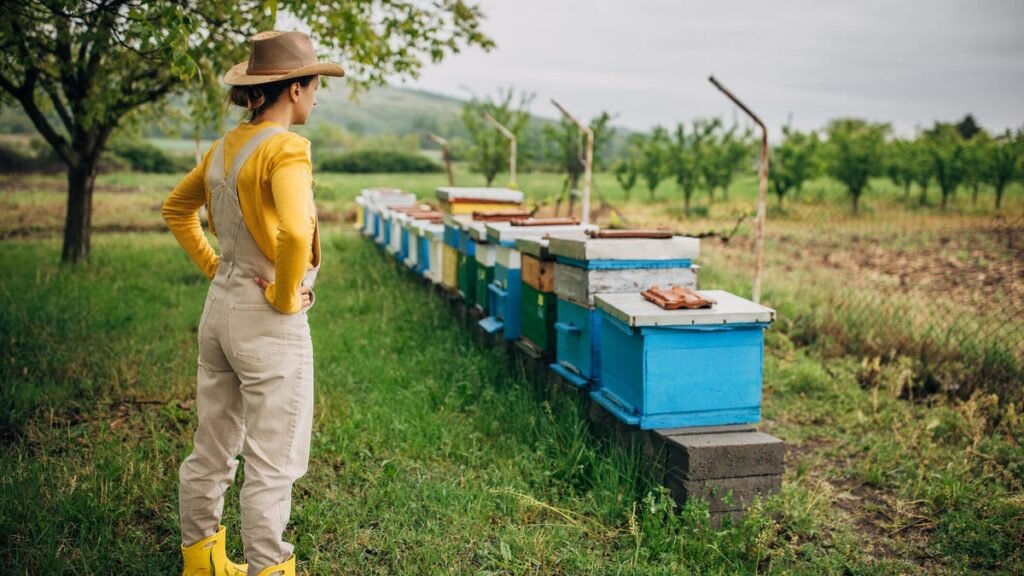 Can AI Find Your Next Obsession? I Tested Its Hobby Suggestions A ohoto of a person wearing overalls standing in front of a row of bee hives