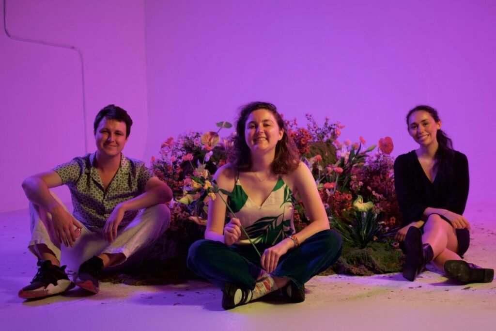 3 young adults sitting with AI gadgets