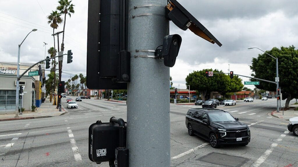 A license plate camera and solar panel at an intersection.
