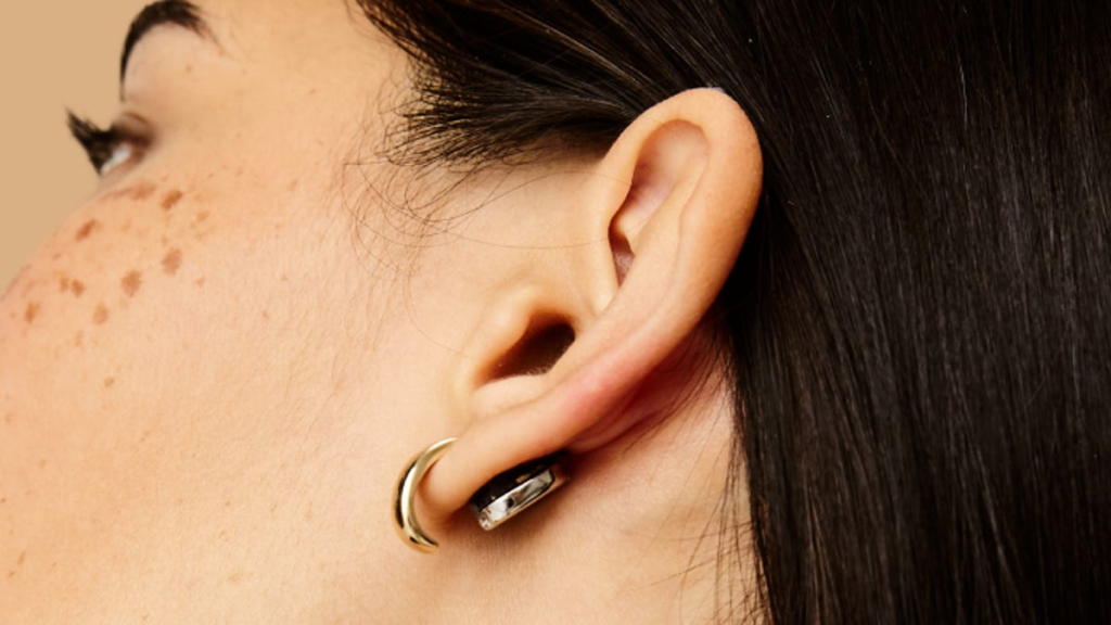 The Lumia 2 smart earrings in a person's ear next to long black hair.