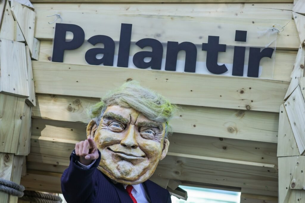 An activist dressed as U.S. President Donald Trump stands in front of a mock Trojan horse