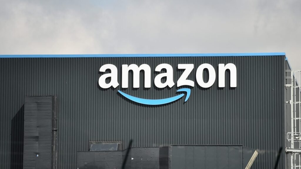 Outside view of a warehouse with a large Amazon logo on the side of the building.