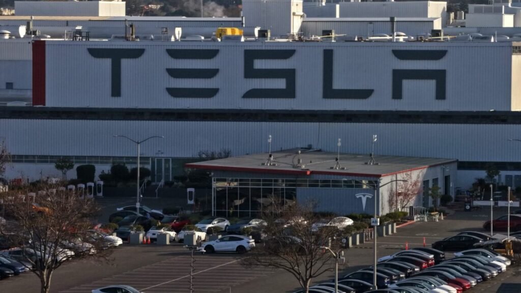 Aerial view of a Tesla factory showing the parking lot and exterior