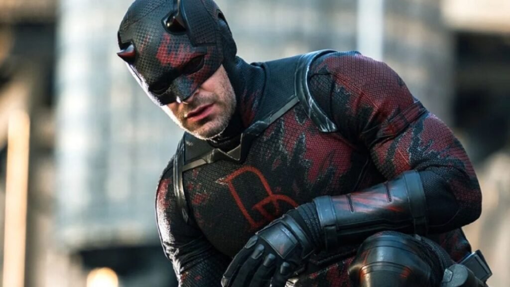 man in devilish superhero costume crouching on a rooftop
