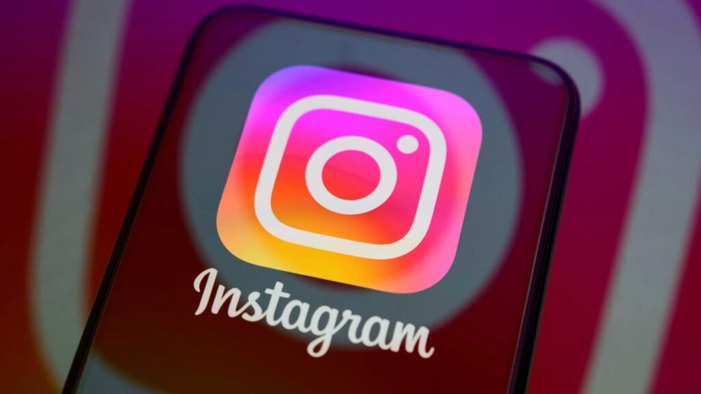 Instagram logo on a mobile phone with a bigger Instagram logo behind it.
