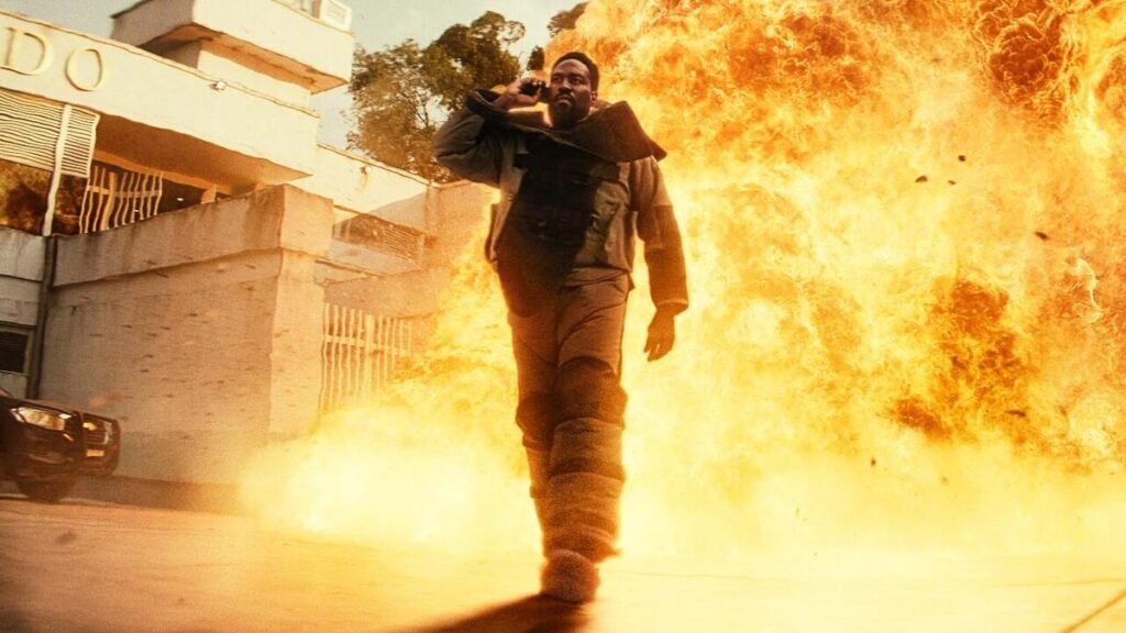 Abdul-Mateen's character is dressed in heavy fireproof gear. He talks on the phone as things explode behind him.
