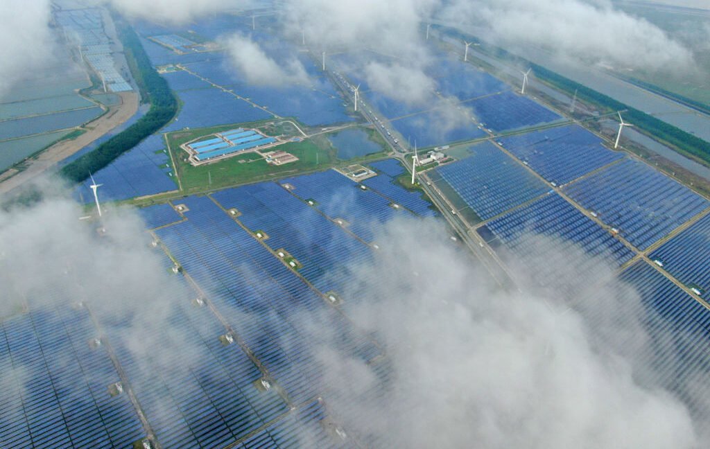 Solar power production undercut by coal pollution Aerial view of a solar power plant that's partly obscured by low-lying clouds.