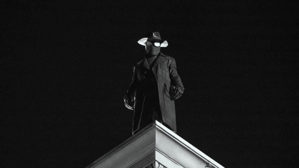 ‘Spider-Noir’ Review: Originality and Elegant Visuals Make for a Strong, Enjoyable Debut spider-noir stands in mask and fedora on roof of building