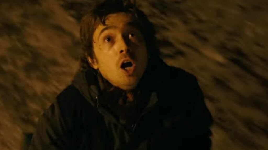 young man looking upward with a look of horror on his face. Late night setting.