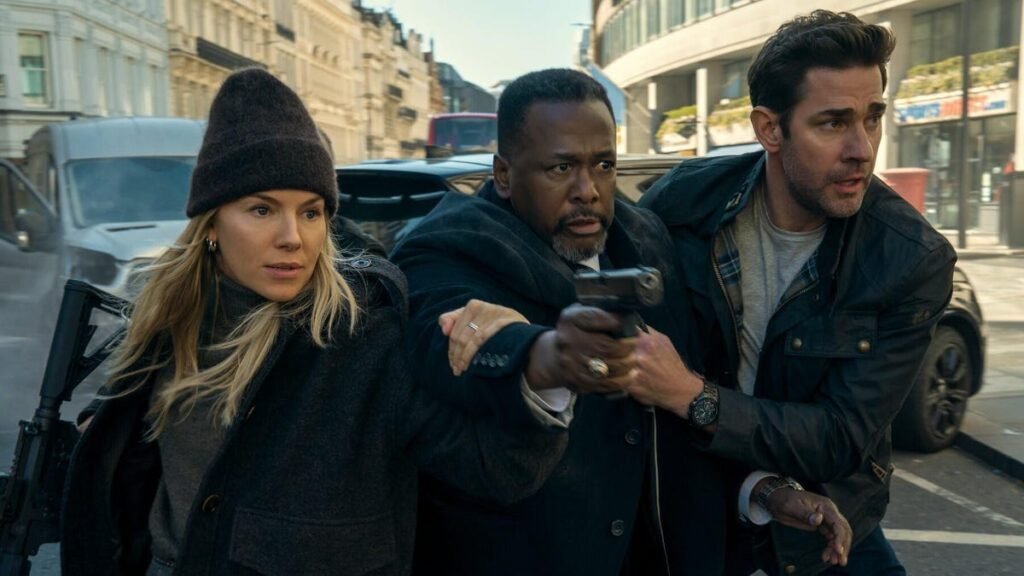 A blonde woman with a beanie and a white man hold onto a black man holding a gun.