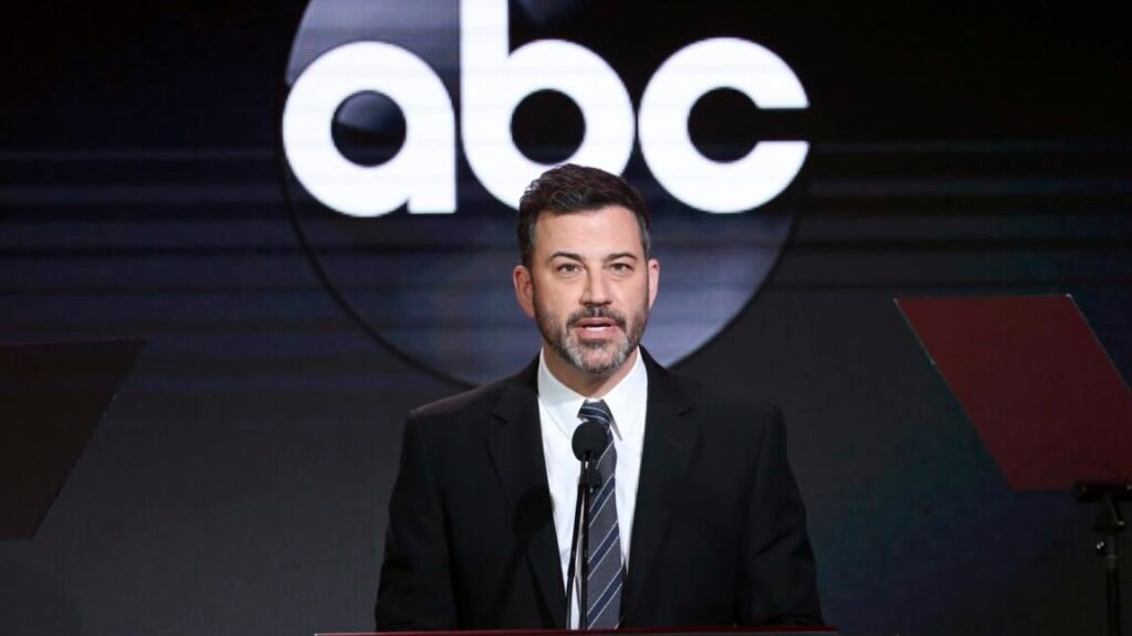 Jimmy Kimmel speaking on stage at an event with an ABC logo in the background.