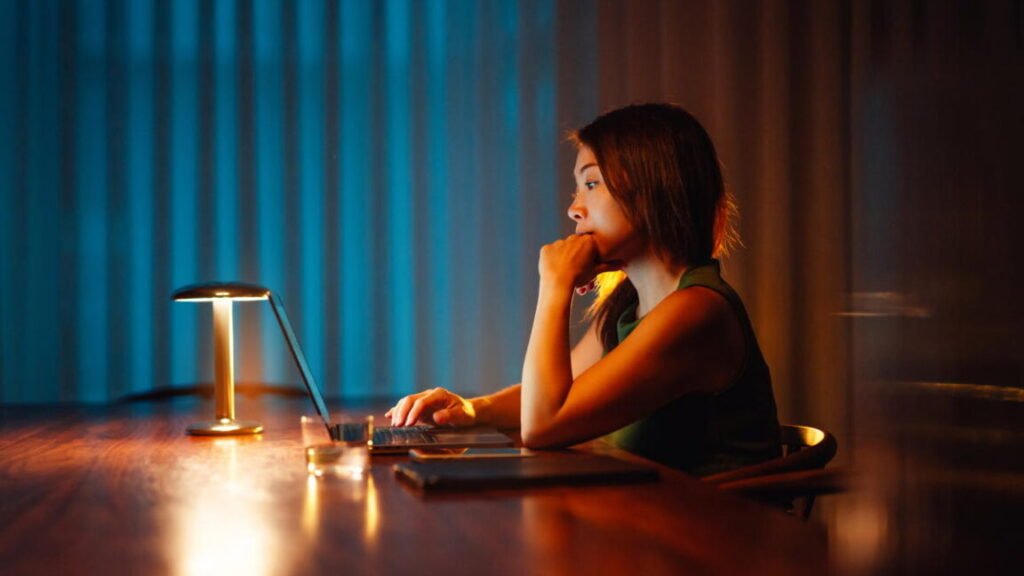 A woman using a laptop at night