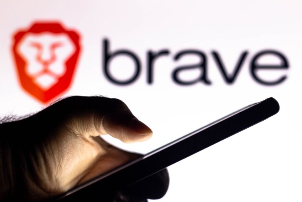 Brave’s browser one-ups Chrome with its new support for email aliases In this photo illustration, a hand of a person holds a smartphone with a Brave Browser logo displayed in the background.