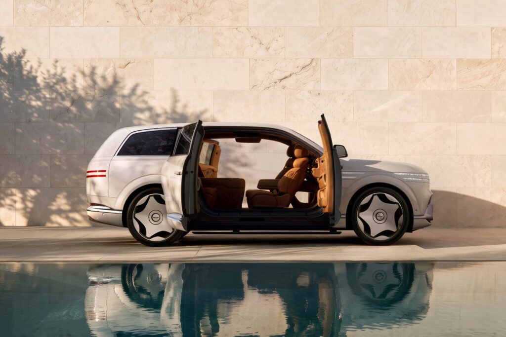 Genesis GV90 Neolun EV parked and reflected in water, its coach doors open