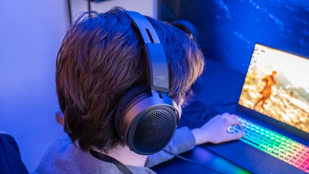 CNET writer Tyler Graham wears the new HyperX headset as he plays Clair Obscur: Expedition 33 in a testing room