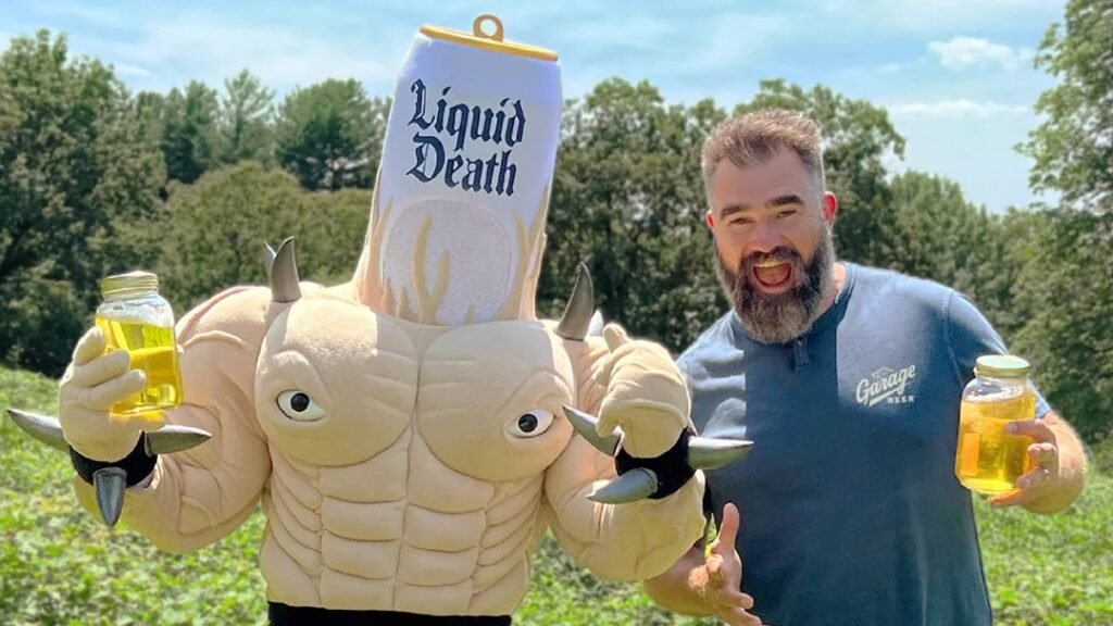 Inside Jason Kelce’s Potty Humor Marketing Ploy Against AI Data Centers Jason Kelce and the Liquid Death mascot stand holding jars of pee.