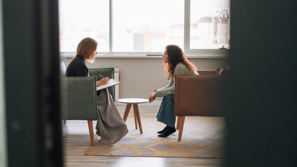 Young woman talking to psychologist in the office