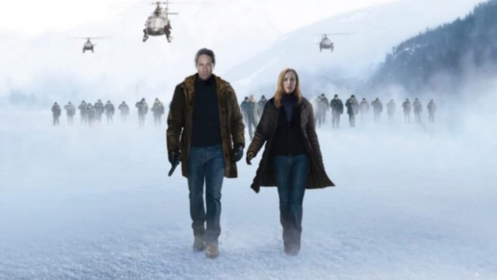 R-rated director’s cut of X-Files film restores Chris Carter’s original horror vision man and red-haired woman walking across a snowy surface with helicopters hovering in the background. A blood-red X stains the snow