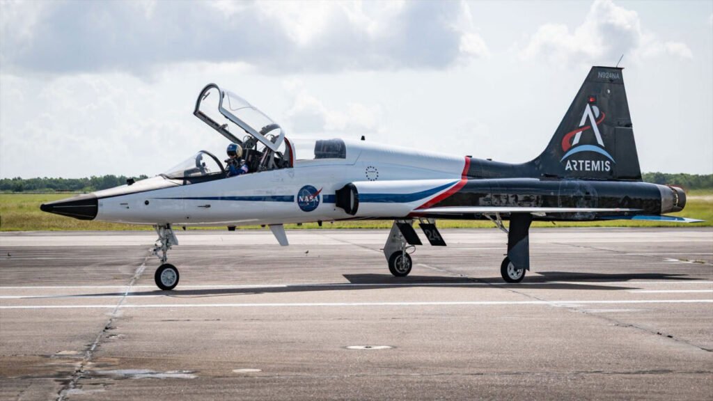 A two-seater supersonic jet sits on the tarmac. Its fuselage is decorated with a custom livery.