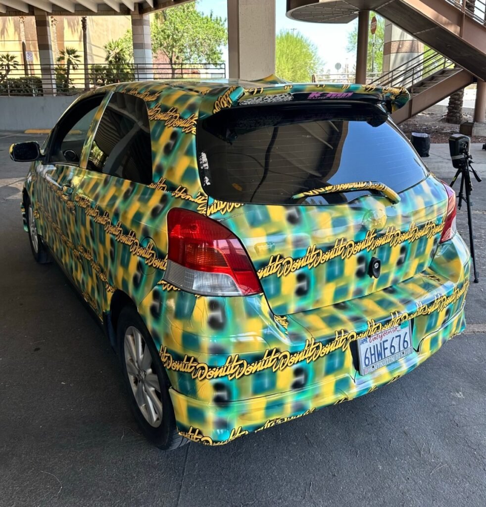 a photo of the toyota yaris covered in a pattern made by Bill Swearingen, as part of a test to see if it can defeat surveillance camera detection.