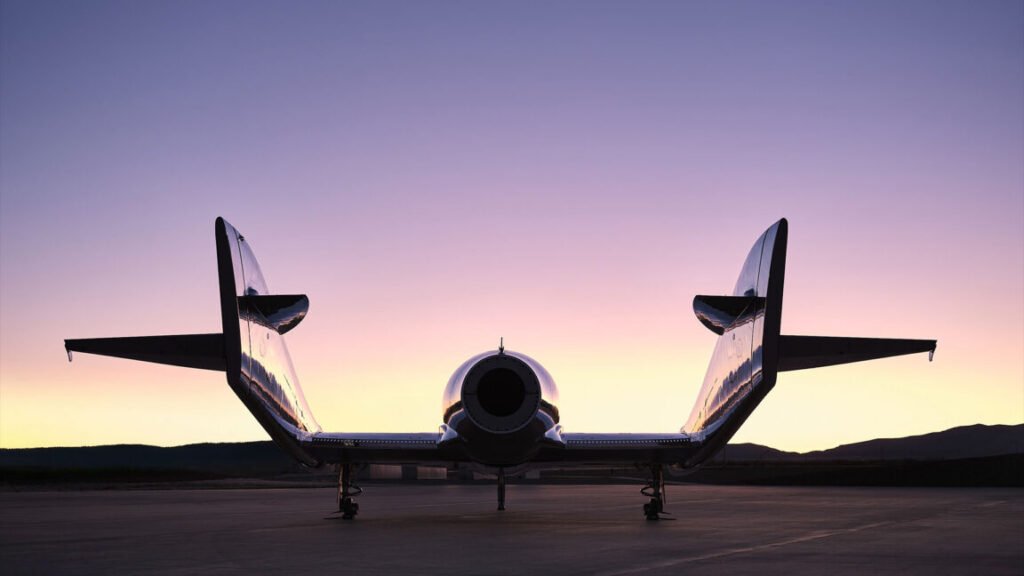 A spaceplane is silhouetted by the sun while sitting outside a hangar
