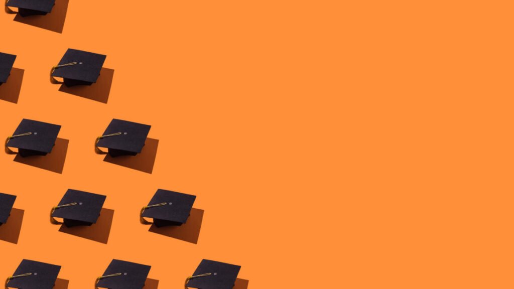 Pattern of black graduation caps with gold tassel with hard shadow, on the left side, on orange background