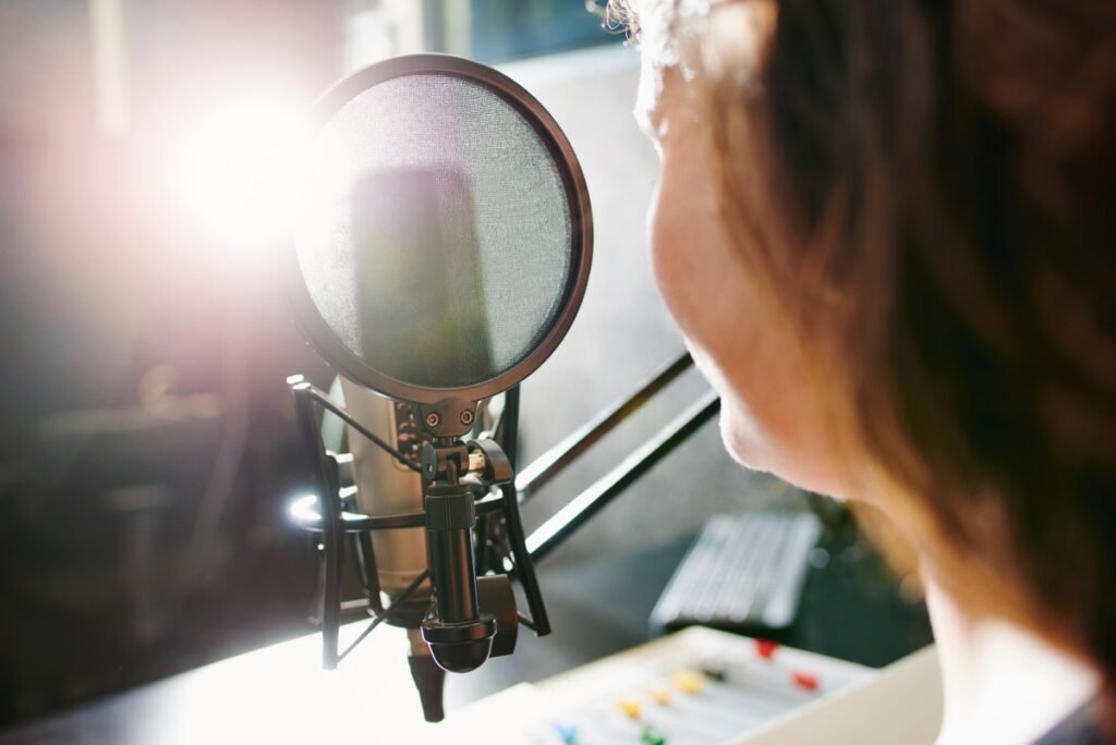 woman speaking into a microphone in a recording studio