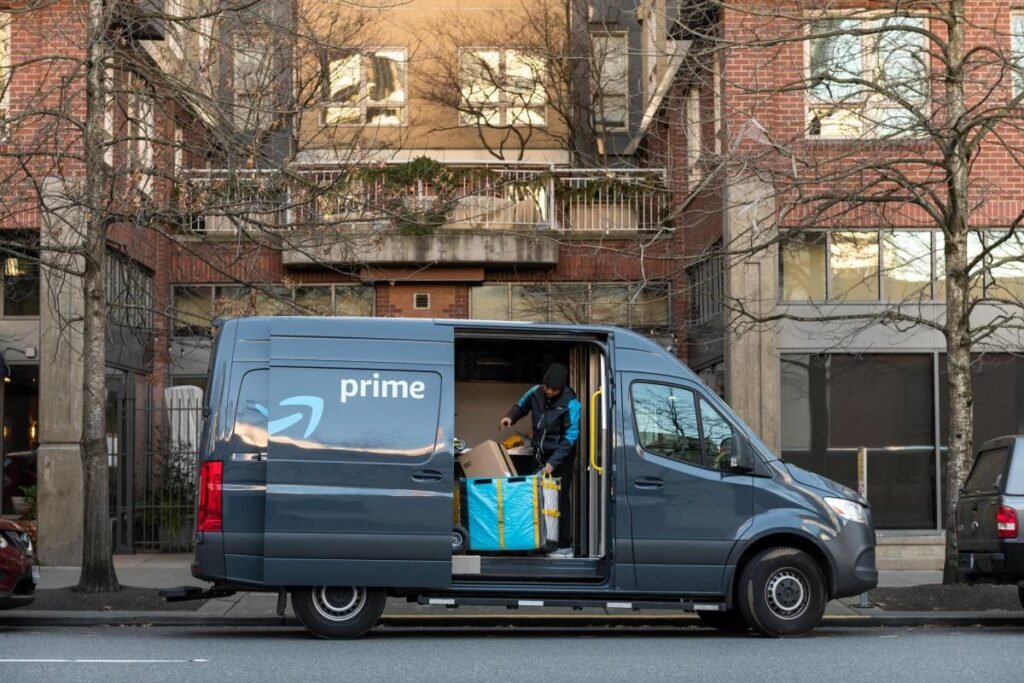 An Amazon driver looks for a package in a delivery van.