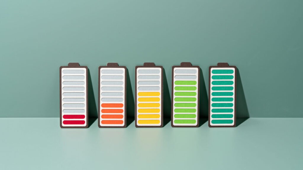 Paper Craft of a row of Rechargeable Batteries Gradually Charging to Full on a Green Background .