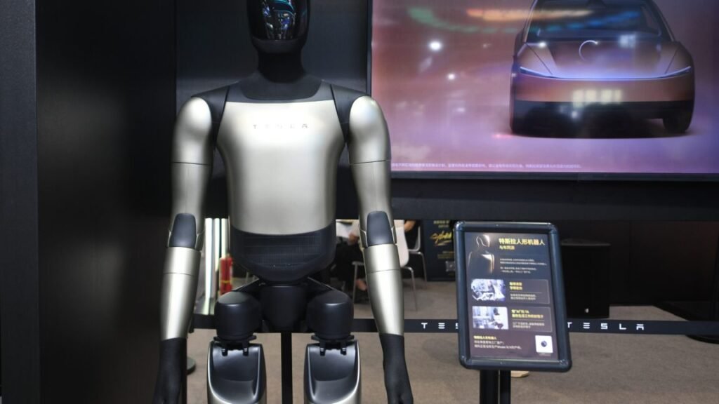 Tesla workers balk at training Optimus humanoid robots as replacements Tesla's Optimus Gen-3 humanoid robot at an exhibition in Hangzhou, Zhejiang Province, China on September 23, 2026. The robot is standing in front of a screen displaying a car.