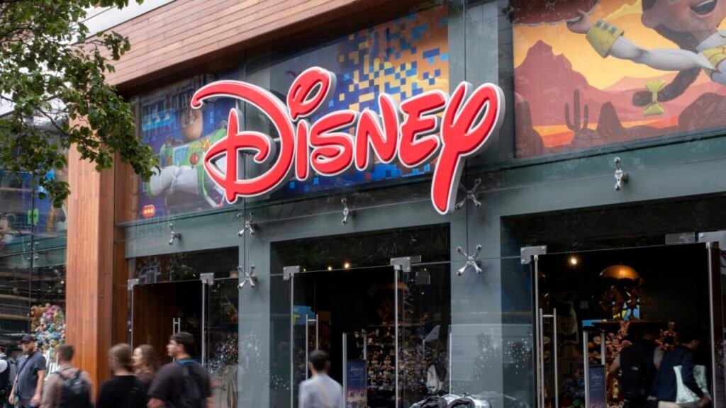 People walking on the sidewalk outside of a Disney store