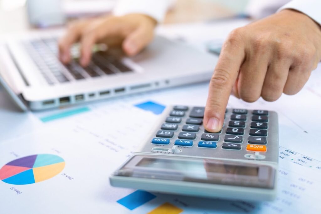 With Tabby, a former accountant is using AI to make accountants obsolete person with one hand typing on a laptop and the other working a calculator